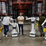 Avatar Robotics. Humanoid workers step into the warehouse floor